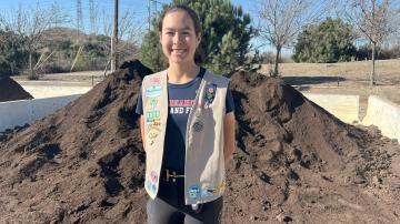 Photo of Bella/Girl Scout in front of compost pile