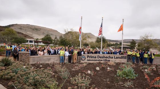 Group photo at Prima Deshecha Landfill. Group of people in front of flags.