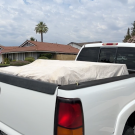 A picture of a car with a tarp covering the load