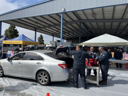 Car parked at marine flare event with trunk open.