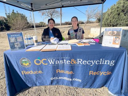 Two people sitting at a table with informational material at a Landscaper Open House at Prima Deshecha Landfill