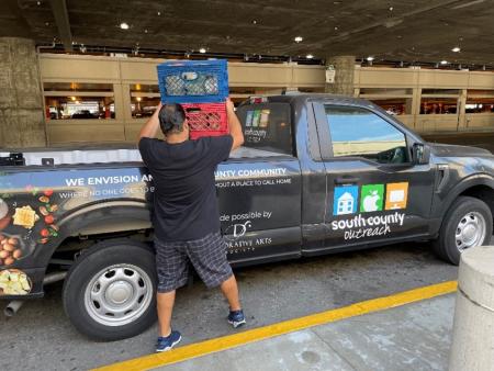 Man loading truck from South County Outreach to deliver the unsold still-edible food to residents in need.